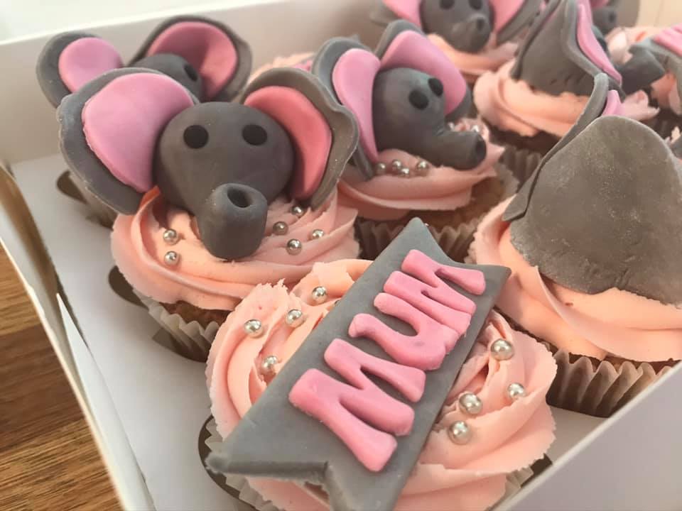 picture of cupcakes with fondant elephants  on top 