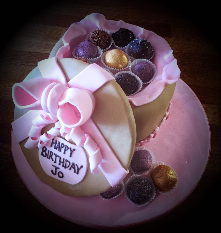 cake covered in fondant with lots of cake balls on top and a lid on the side 