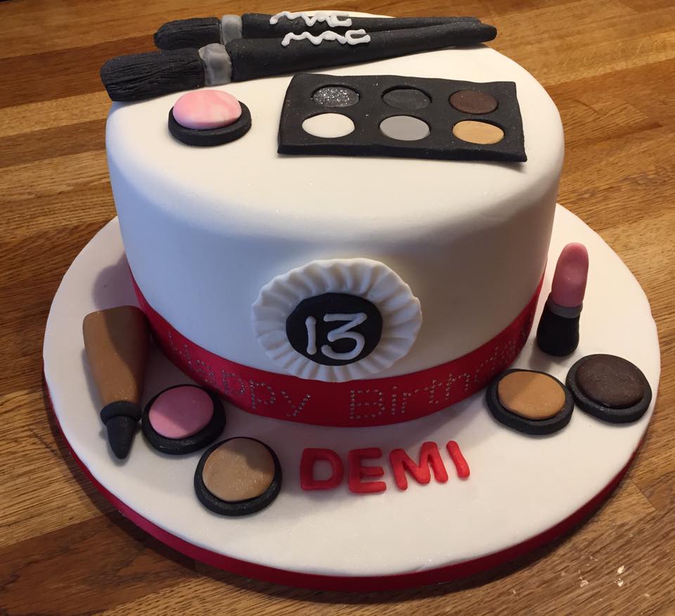 Round cake covered in white fondant with lots of fondant make up item on cake  bt creative cakes by kaz 