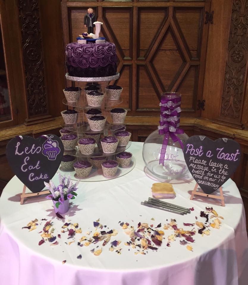 large round cake sitting on top of a cupcake tower 