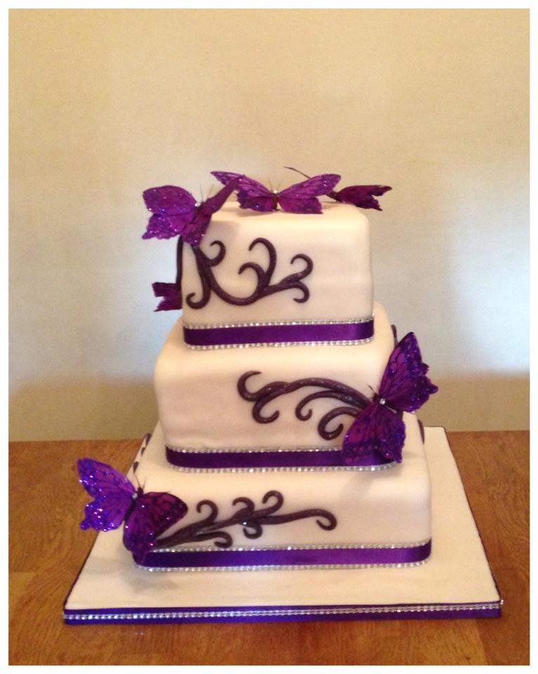 3 tier wedding cake with purple butterflies and ribbon 