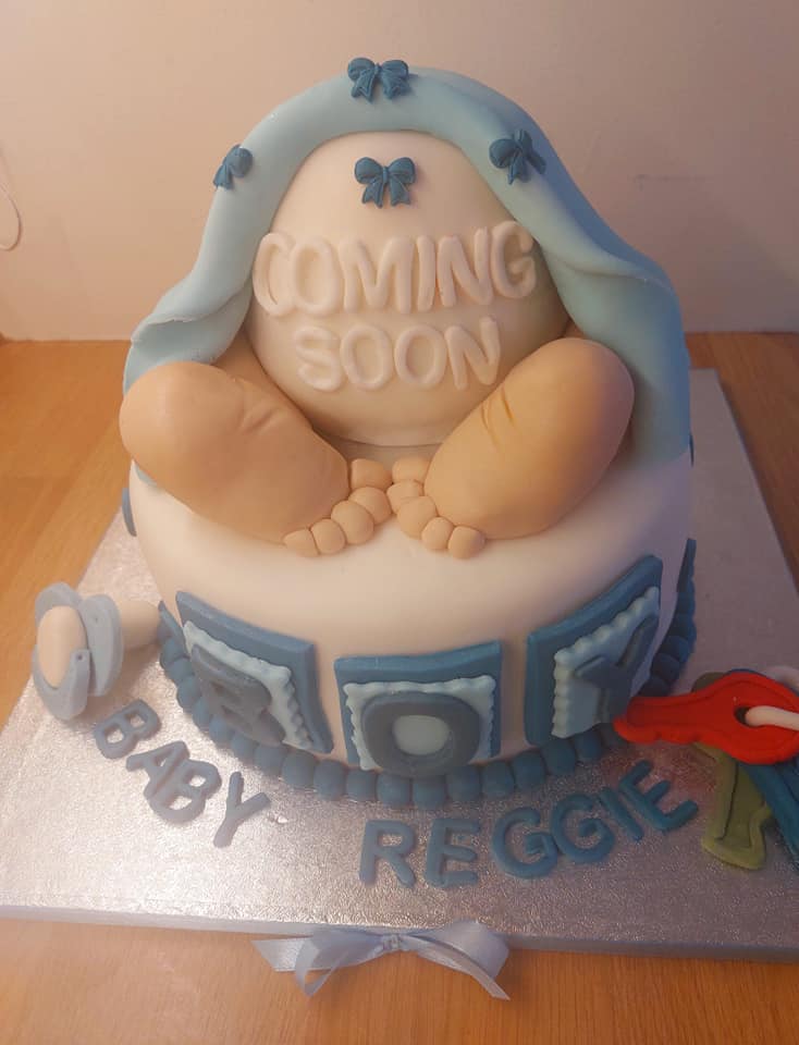 round cake covered with fondant with a babies bum and feet on top 