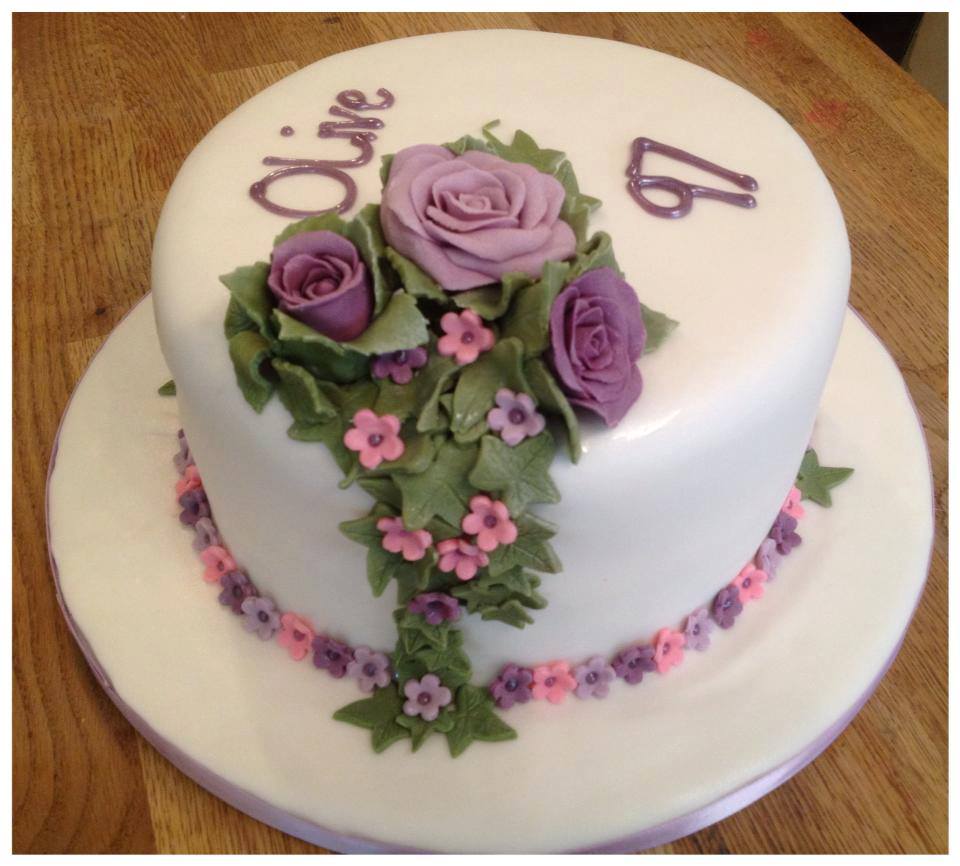 round cake covered in white fondant with fondant roses, leaves and flowers  by Creative Cakes by Kaz