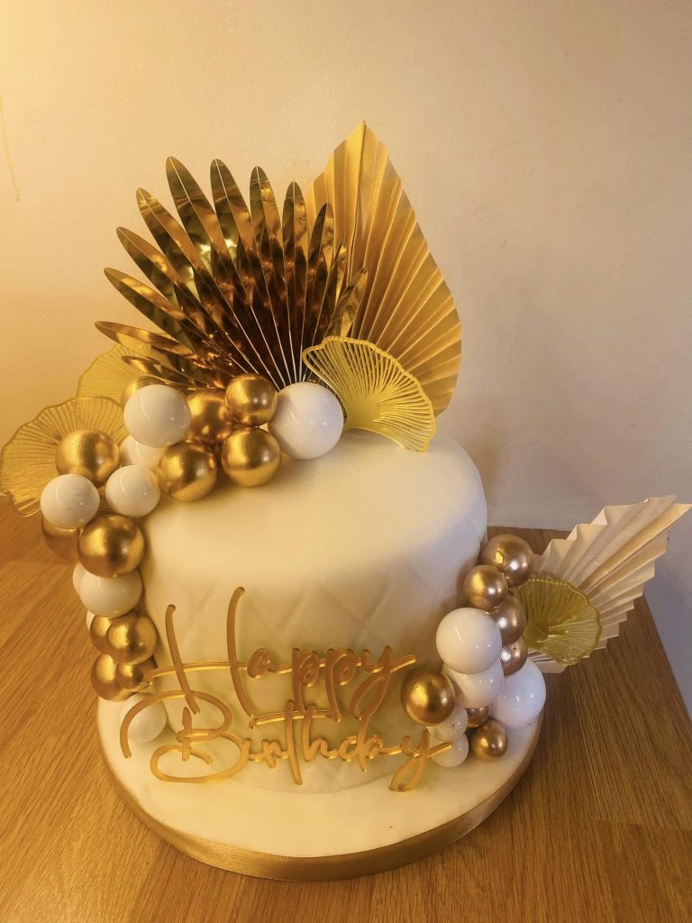 round cake covered in white fondant with a gold boho theme by Creative Cakes by Kaz