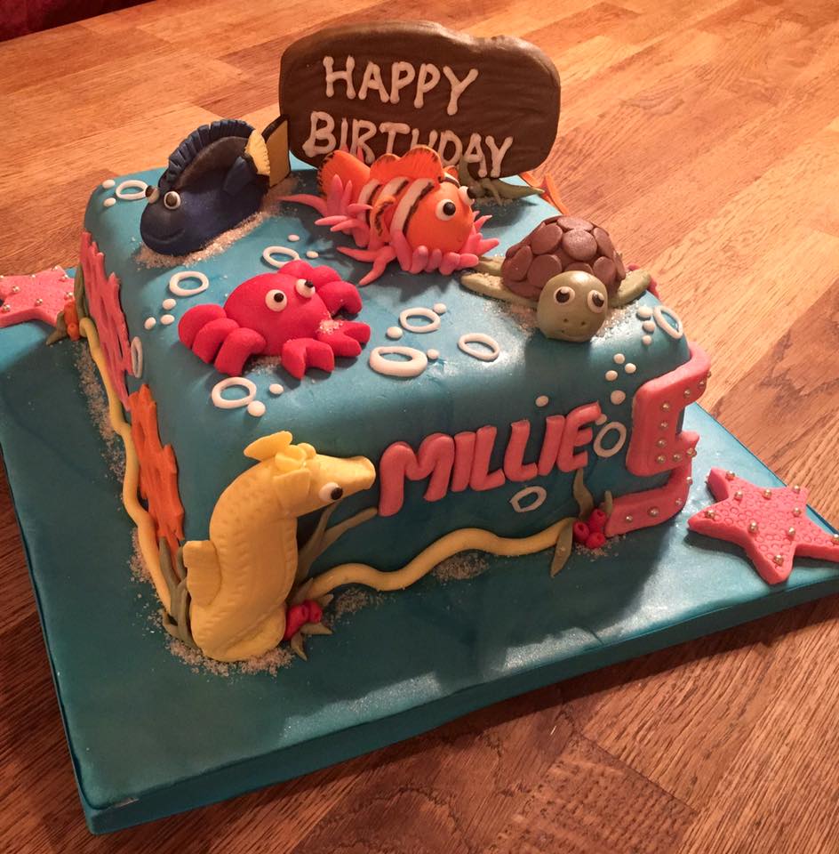 square cake covered in blue fondant with lots of sea themed items by Creative Cakes by Kaz
