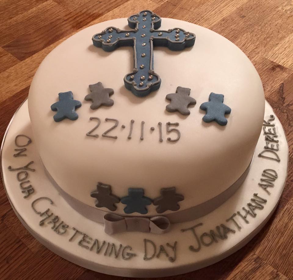 round cake covered in white fondant with a blue cross and teddy bears on top 
