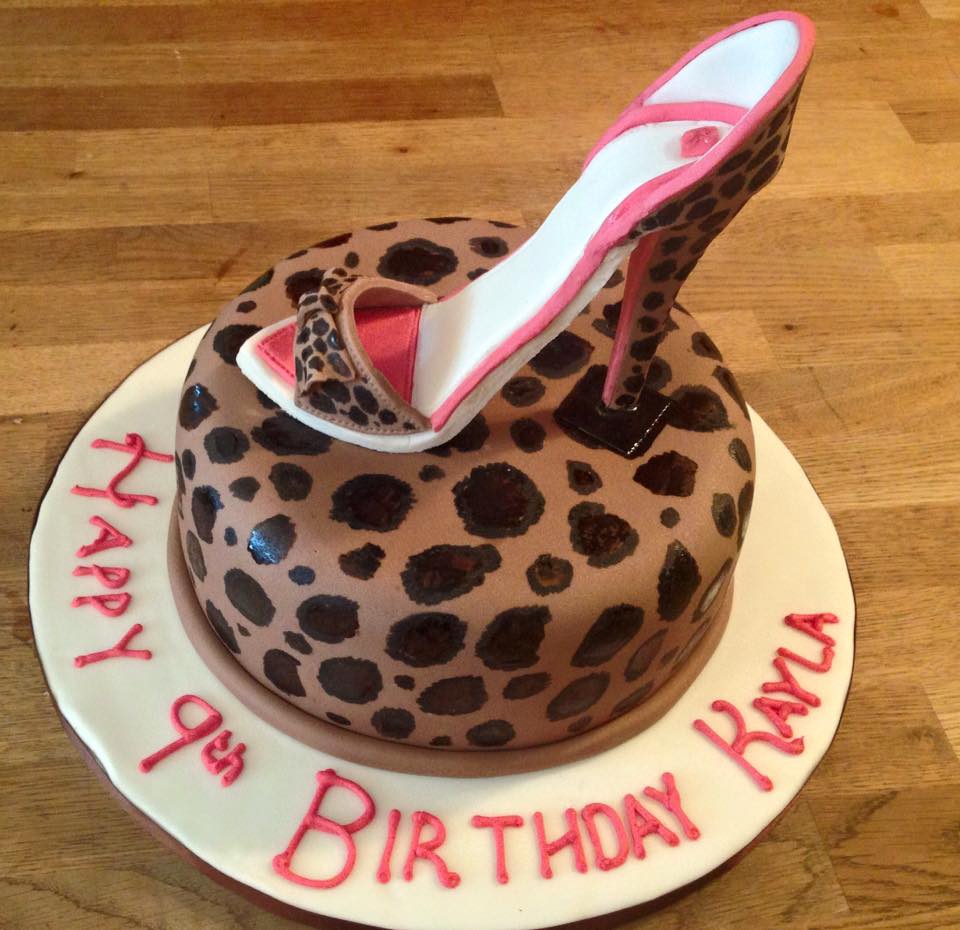 Round cake covered in leopard print  fondant with a fondant high heel shoe on top 